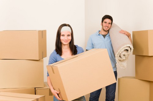 Two movers carrying furniture in a Notting Hill flat move