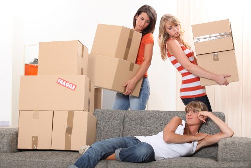 Local furniture removal team navigating a narrow West London staircase